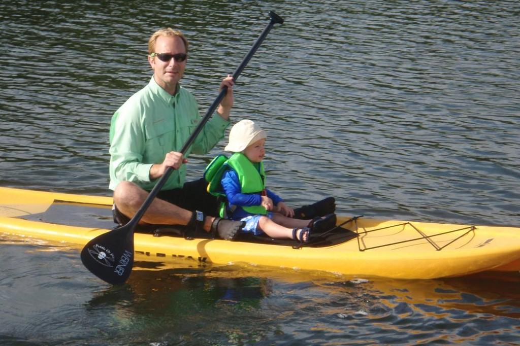 Father and child exploring on a stand up paddleboard during a 2010 outing