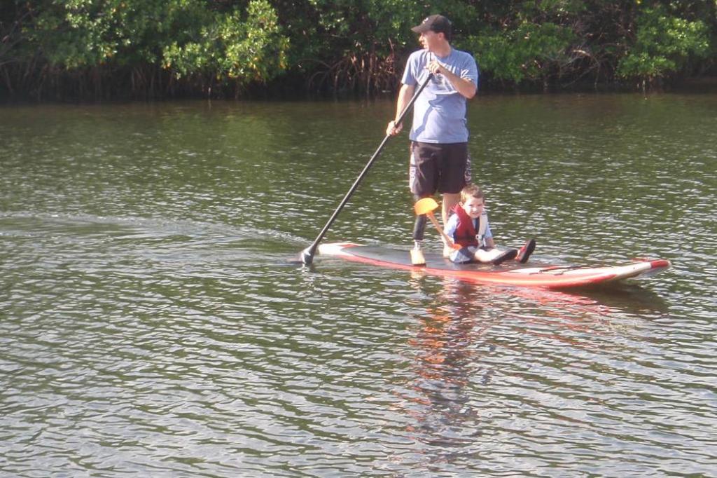 Father and son sharing a stand up paddleboard outing in August 2010