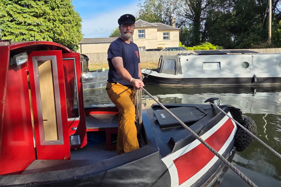 Jeffrey Fabiszewski wearing a navy Breton mariner's cap while handling a rope aboard a British narrowboat during a July 2025 American Sea Scout expedition in England.